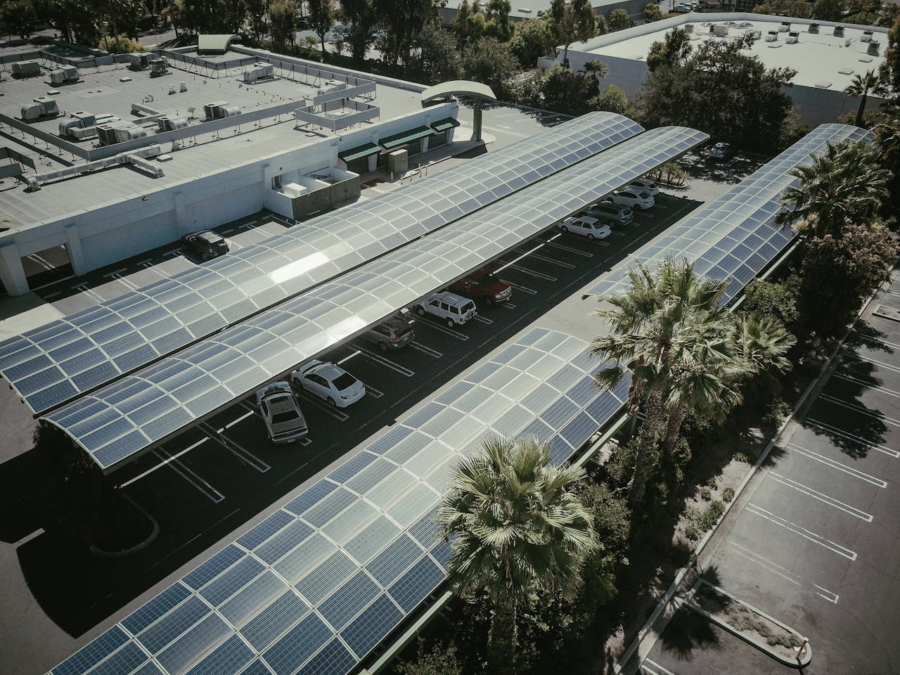 Aerial view of a parking lot with solar panel canopies, showcasing clean energy usage.